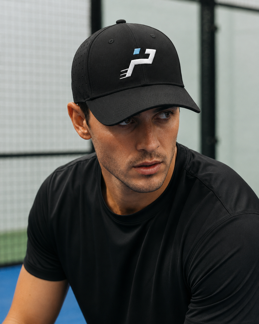 Casquette Technique Airflow noire Impulse Padel portée de face sur terrain de padel