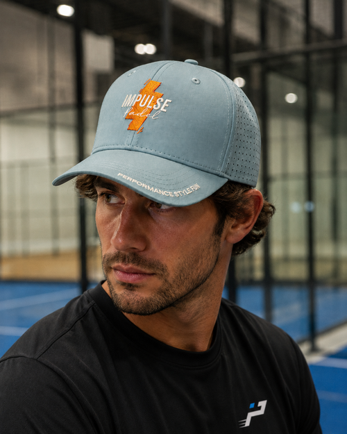 Casquette Technique Sunrise Impulse Padel portée de face sur terrain indoor de padel