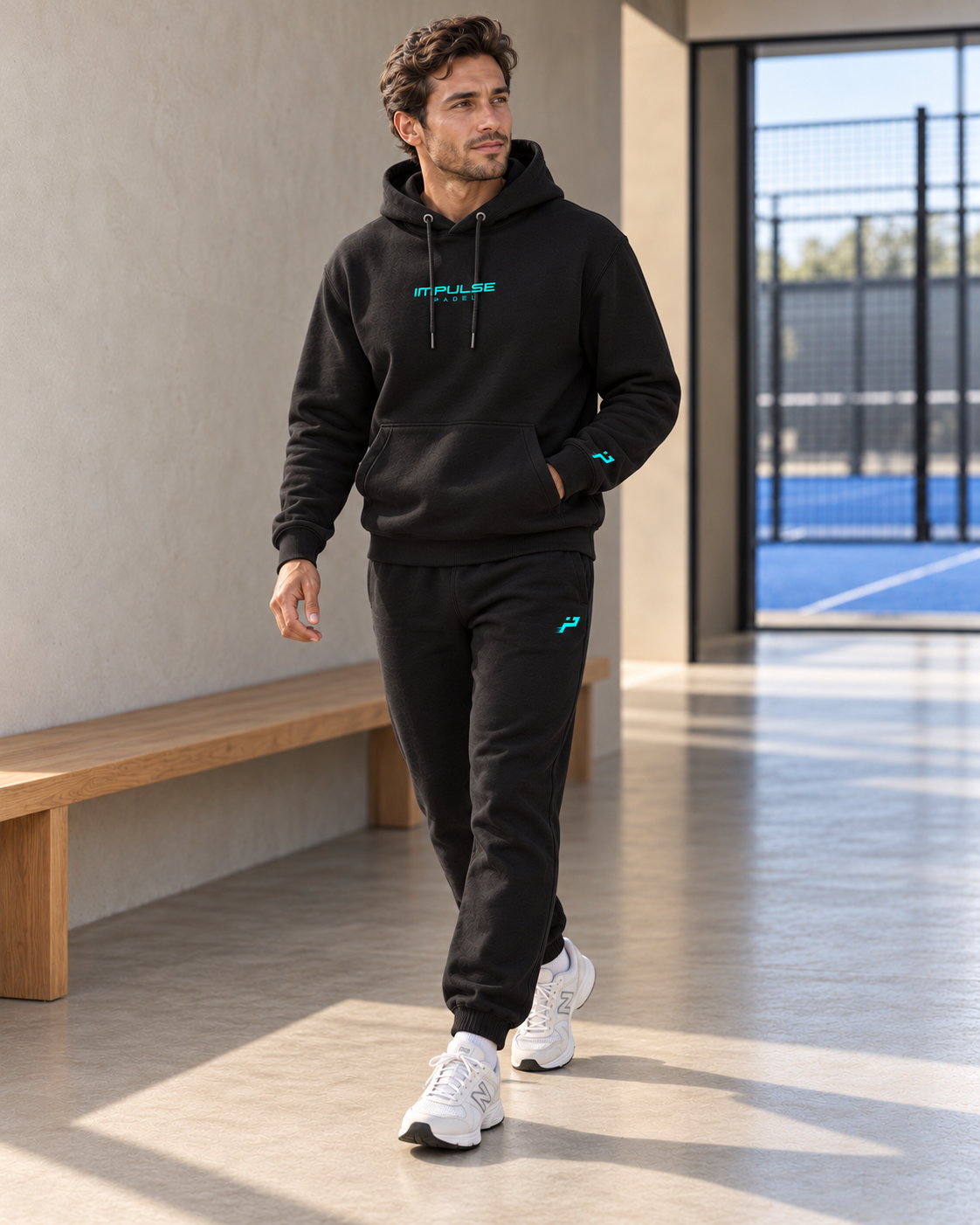 Ensemble SUNSET homme noir porté en mouvement dans un club de padel