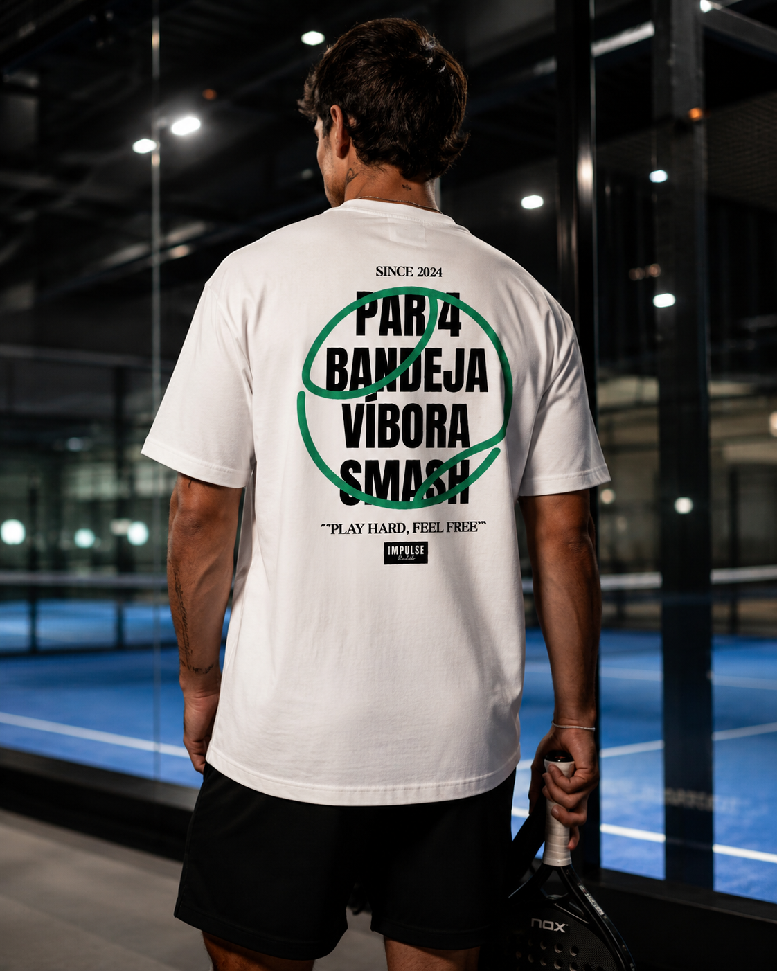 T-shirt Play Hard Feel Free blanc et vert porté de dos sur terrain de padel