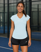 Détail de la coupe ajustée et du bas arrondi du t-shirt technique femme bleu glacier